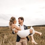 A joyful, loving couple in a field, embracing under the summer sun.